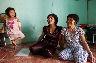 Mai and her 64 year-old mother talks to Hung Phan about their application for a US visa. The young girl to Mai's left is her granddaughter.